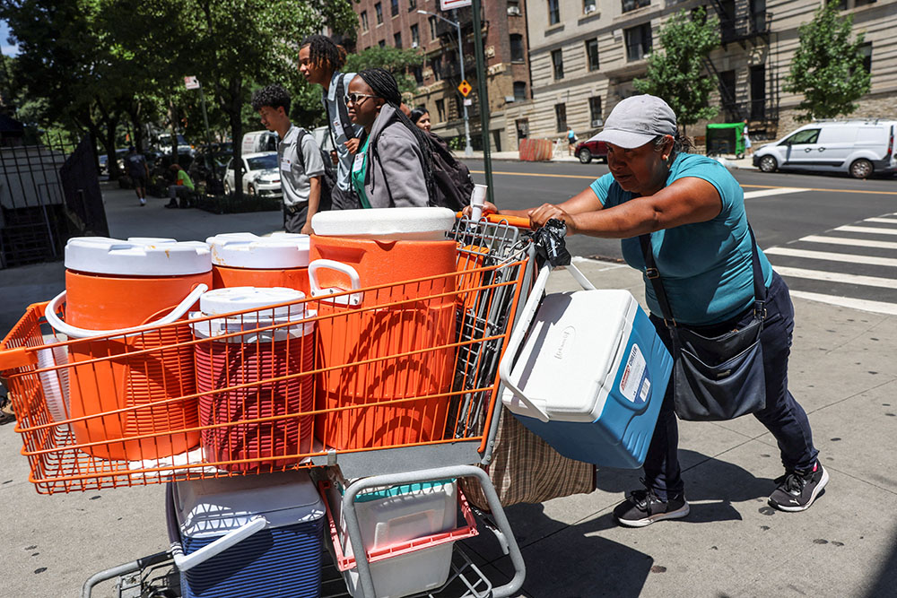 A woman pushes a shopping cart full of coolers and cold beverages during a summer heatwave in New York City July 11, 2024. Seventeen U.S. states set annual heat records in 2024, the hottest year to date. (OSV News/Reuters/Caitlin Ochs)